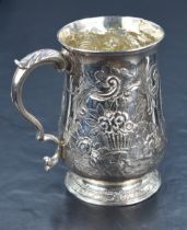A George III silver tankard of baluster form, having a slightly flared rim and scroll handle, raised