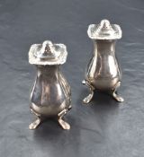 A pair of George V silver pepperettes of square bulbous form, having egg and dart style rims,
