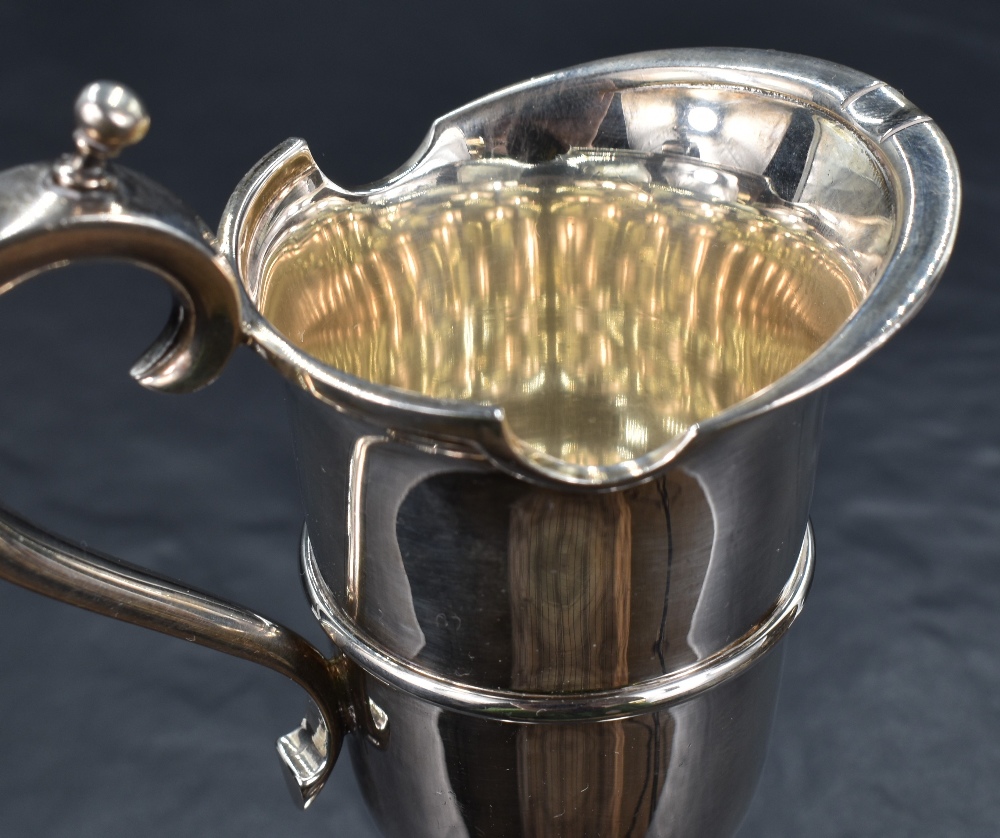 A Queen Elizabeth II silver cream jug, a reproduction of a 17th century ewer of heavy gauge with - Bild 2 aus 4