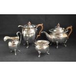 A George V silver four-piece tea set comprising a tea pot, hot water pot, sugar and cream, all of