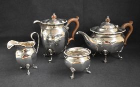 A George V silver four-piece tea set comprising a tea pot, hot water pot, sugar and cream, all of