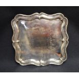 An Edwardian silver tray, of square form with moulded and shaped Chippendale influenced rim