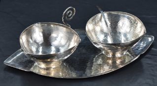 An Art and Crafts silver plated preserve set, comprising a cup and sugar bowl of rounded
