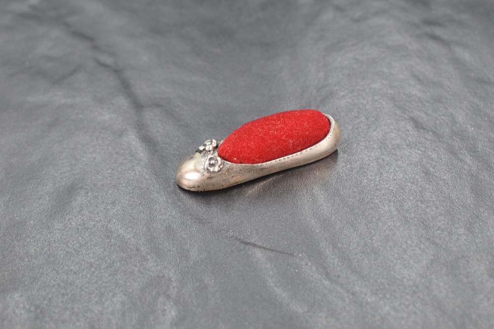 A 20th century silver novelty pin cushion modelled as a ballet shoe having red velvet to the centre,