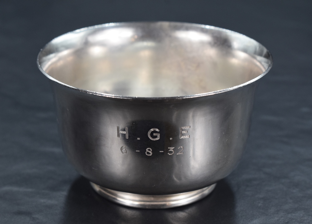 A George V silver sugar bowl of circular form, having a flared rim and plain body raised on a