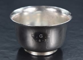 A George V silver sugar bowl of circular form, having a flared rim and plain body raised on a