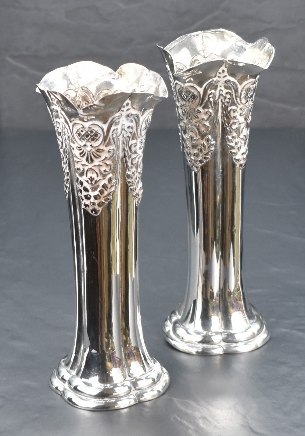 A pair of Edwardian silver vases, of lobed column form having embossed damask swag decoration, marks