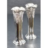A pair of Edwardian silver vases, of lobed column form having embossed damask swag decoration, marks