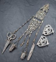 A Victorian silver chatelaine having three articulated moulded and pierced sections suspending