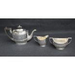 A group of three silver tea wares, comprising a tea pot having wooden handles, sugar and milk each