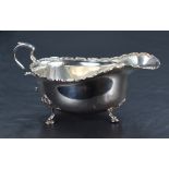 A George V silver sauce or gravy boat of traditional design, with Chippendale style rim, generous