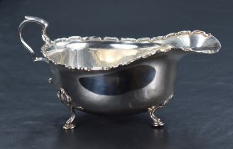 A George V silver sauce or gravy boat of traditional design, with Chippendale style rim, generous