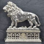 A Victorian silver plated fireside ornament depicting 'the British Lion' situated on a platform