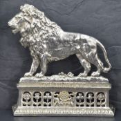 A Victorian silver plated fireside ornament depicting 'the British Lion' situated on a platform