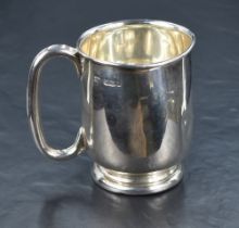 A George V silver tankard of circular form with looped handle, raised on a moulded circular foot,