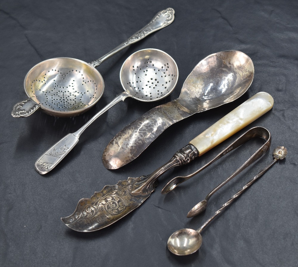 An assortment of silver flatware and cutlery, including a Russian fiddle pattern sugar sifting spoon