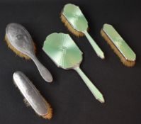 A George V three-piece silver and green guilloch enamel dressing table set, comprising a clothes