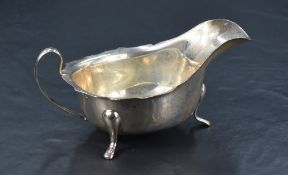A George VI silver sauce boat of traditional design, with Chippendale style rim, generous spout