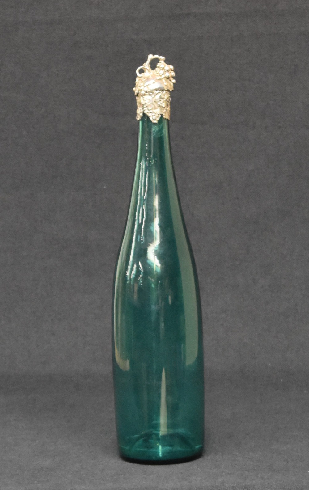 A Victorian silver topped emerald green glass wine bottle, the silver top and mounting having a