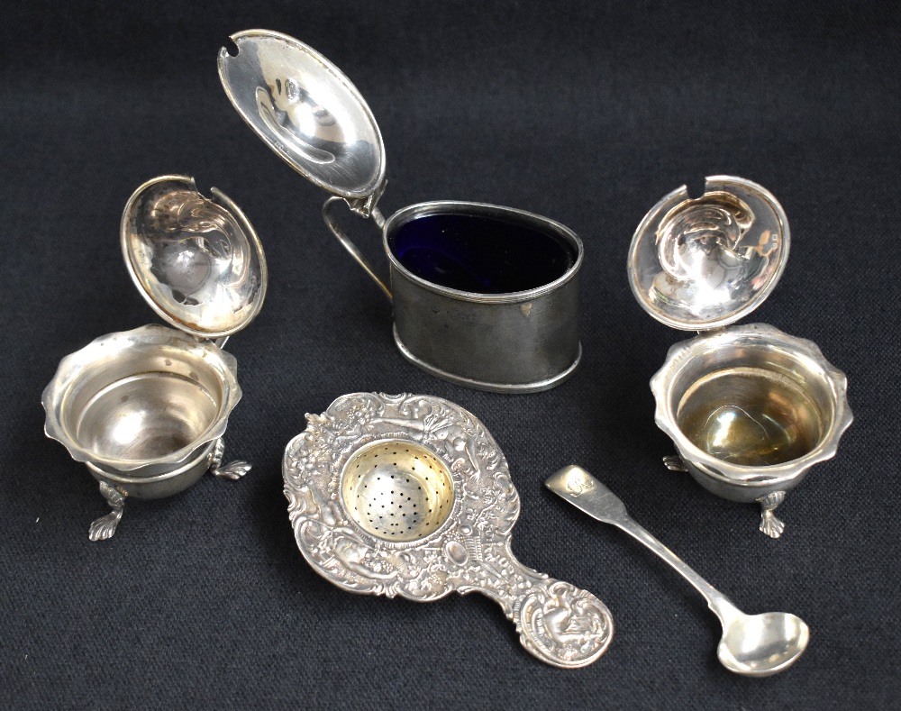 A group of silver table wares, comprising a decorative embossed tea strainer having cherubs and - Image 2 of 2