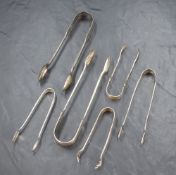 A group of six silver sugar tongs of various sizes, including a pair having decoratively engraved