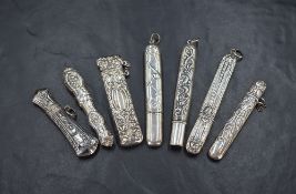 A group of seven silver needle cases, including one of elongated oval form having embossed bead