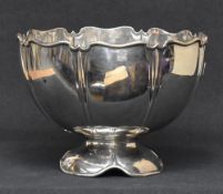 An Edwardian silver punch bowl, of circular lobed petal moulded design raised on a conforming