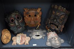 A collection of wooden and terracotta masks.