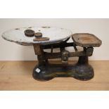 A set of heavy cast metal vintage weighing scales with weights.