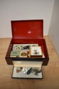 A lacquered box containing an assortment of costume jewellery including various clip on earrings,