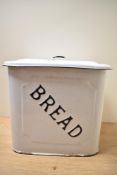 A vintage white enamel bread bin with black script.