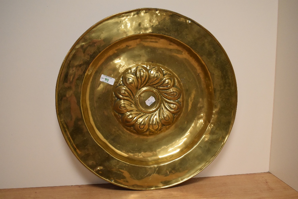 An antique Continental brass alms dish, the raised centre with a swirl of gadroons, measuring 46cm