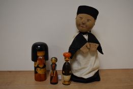An early 20th century Oriental hand puppet and three wooden figures.