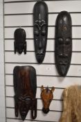 A selection of African hardwood carved masks, of varying sizes, possibly of Kenyan origin, and