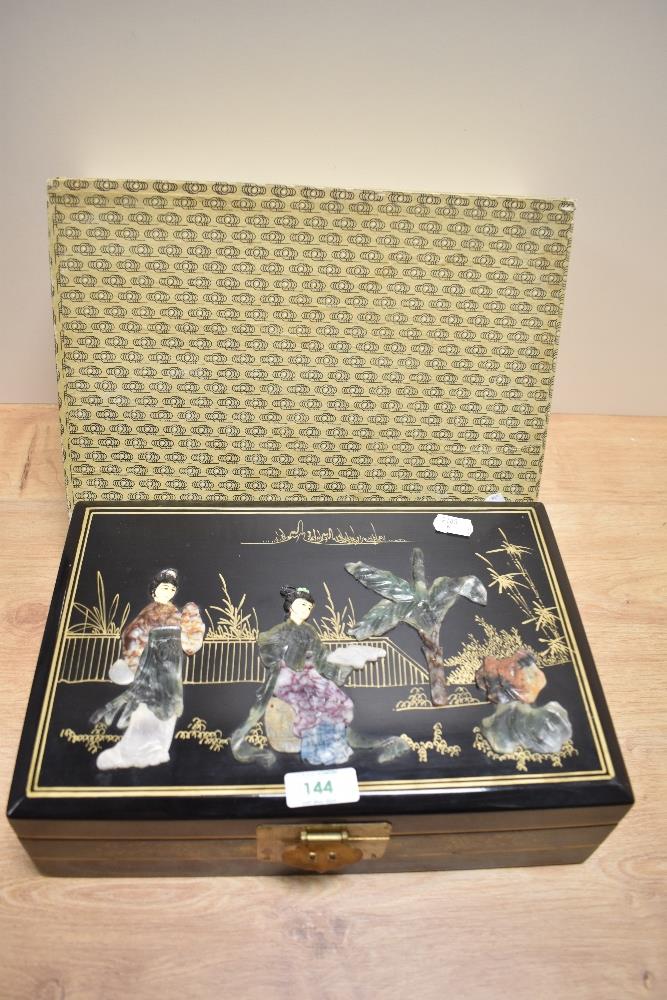 A 20th Century Chinese lacquered jewellery box, with soapstone inlaid decoration, heightened in