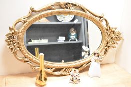 A 20th Century reproduction giltwood mirror, of oval form, measuring 70cm high, together with a