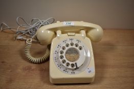 An early to mid-20th Century bakelite rotary dial telephone in cream, measuring 12cm high