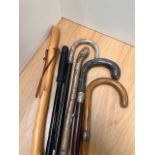 A selection of walking sticks, to include a stick with bone handle and silver hallmarked collar, and