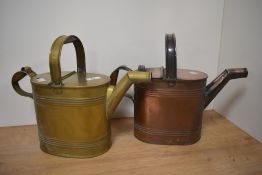 Two antique brass hot water cans, one of cooper and the other of brass.