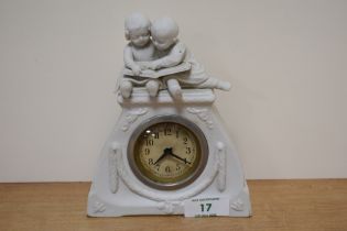 A 20th century white ceramic mantel clock, depicting two young children reading a book to top and