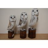 A group of three modern wooden owl studies.