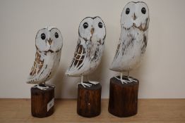 A group of three modern wooden owl studies.