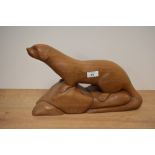 A carved hardwood depiction of an otter, approx 43cm long.