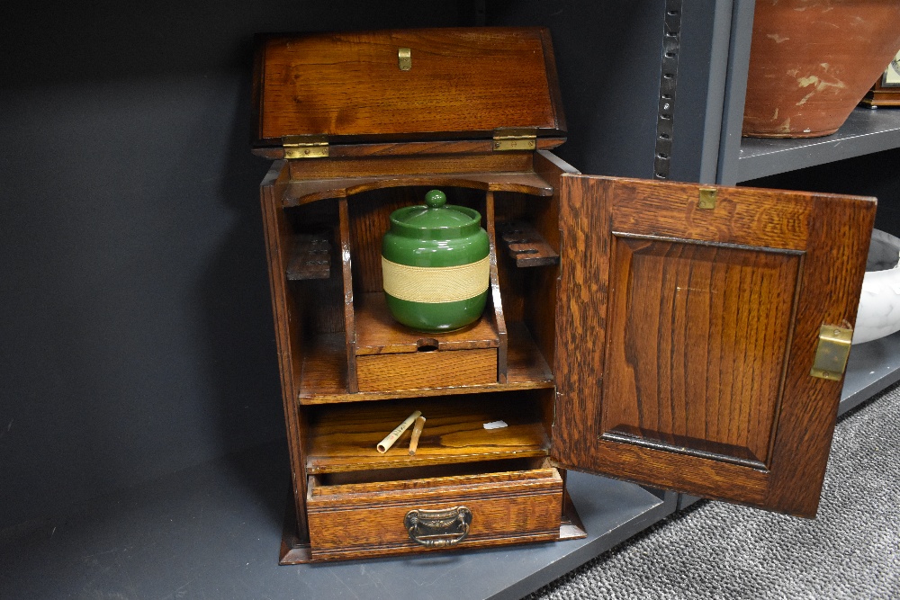 An Arts and Crafts oak smokers cabinet with embossed metal decoration to door, with internal - Image 2 of 2