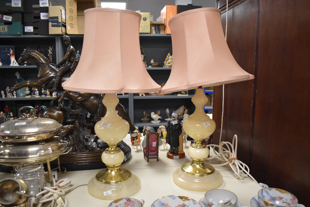 Two traditional brass and onyx or onyx effect table lamps, with peach shades.