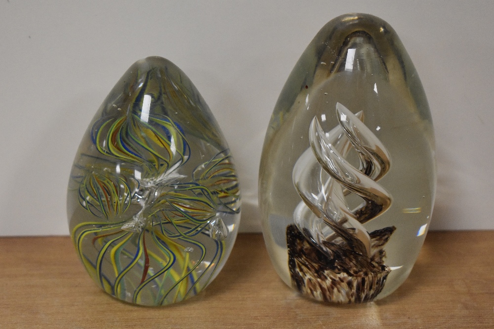 Two glass paperweights, one having colourful multi spiral twists, the other with air twists and