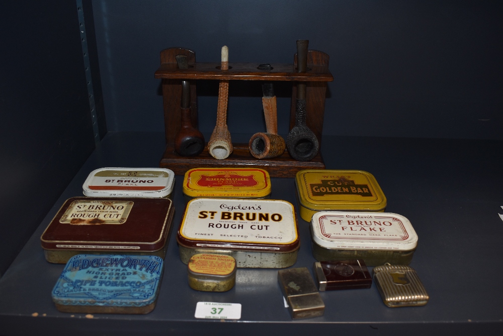 A selection of vintage tobacco and snuff tins, three vesta cases and a pipe rack with four vintage