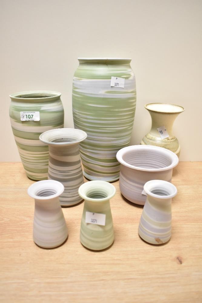 A collection of studio pottery, having matte finishes in lilacs, greens a beige.