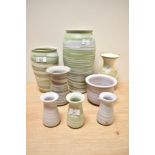 A collection of studio pottery, having matte finishes in lilacs, greens a beige.