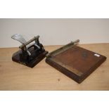 A vintage hole punch and a wooden paper guillotine.